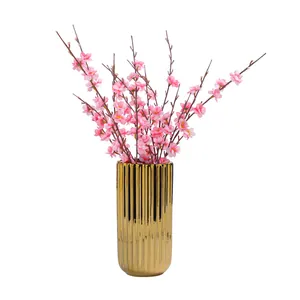 Moderne galvanisierte goldene Keramikvase mit künstlichen rosa Kirschblüten für die Deko