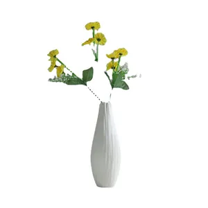 White ceramic fluted vase with yellow daisy flowers for modern home table centerpiece