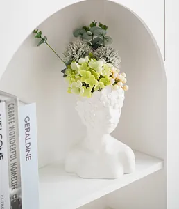 Elegant white ceramic bust vase with faux floral arrangement on a display shelf.