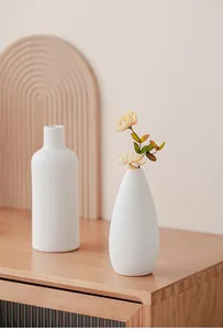 Detail van witte geribbelde keramische vazen in een minimalistische wabi-sabi-stijl