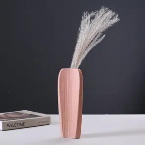 Minimalist pink ceramic vase with vertical texture and dried pampas grass for home decor.