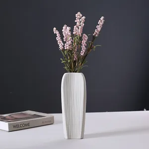 Elegant vintage white textured ceramic vase featuring pink flowers for modern home decor