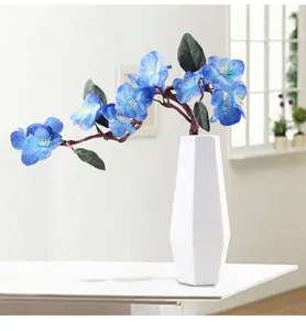 Close-up detail showing the geometric texture of a white vase with blue flowers.