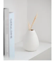 Detailopname van minimalistische witte keramische vaas met fijne gestreepte textuur