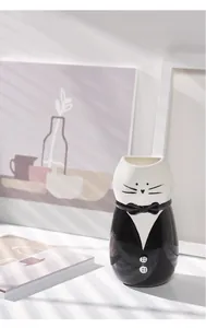 Gedetailleerde weergave van creatieve kat tuxedo keramische vaas met elegante vlinderdas