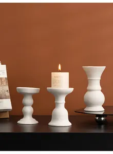 Modern white ceramic candle holders set displayed on a dark table in a cozy room