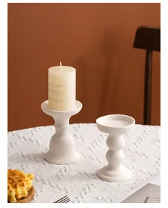 Close-up of elegant white ceramic candle holders on a lace tablecloth for home decor