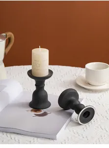 Elegant matte black ceramic candle holder set displayed on a white textured tablecloth