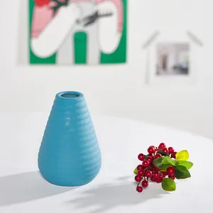 Modern blue ceramic vase with textured ridges on a white table decoration