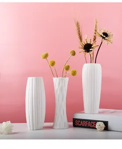 Detail of modern minimalist white ceramic vases with textured patterns and dried flowers