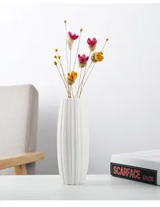 Detailed view of modern minimalist white ceramic vase featuring vertical texture patterns
