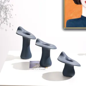 Drie elegante blauwe Scandinavische keramische kandelaars gerangschikt op hoogte op tafel