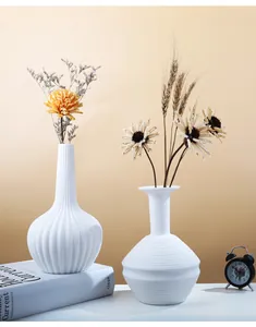 Close-up of minimalist white ceramic vases with elegant vertical and horizontal lines