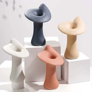 Detail van moderne organisch gevormde keramiek kandelaars in matte Scandinavische kleuren.