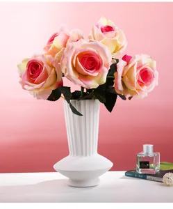 Detailed view of a white ceramic vase with vertical line textures in a home setting