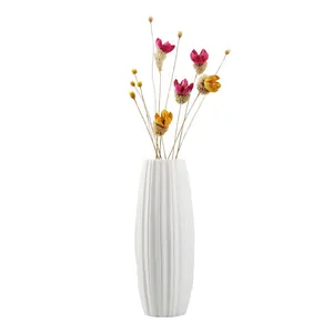 Elegant modern white ceramic ribbed vase featuring colorful dried flowers for home decor
