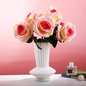 Elegant minimalist white ribbed ceramic vase with pink silk roses for modern home decor