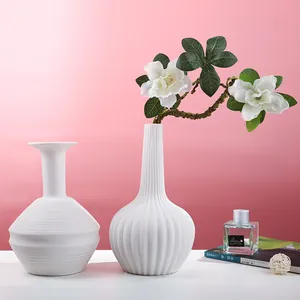 Minimalist white ceramic vases with vertical and horizontal ridged textures for home decor.