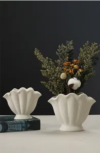 Elegant white shell-shaped ceramic vase with dried flower arrangement for home decor