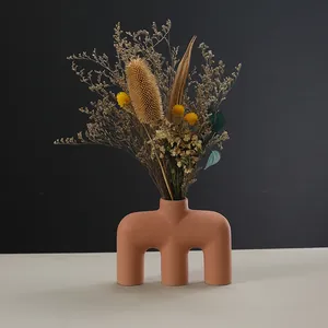 Jarrón de cerámica artística minimalista moderna en terracota con ramo de flores secas
