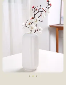 Moderne weiße Keramikvase mit vertikalen Rillen in einer hellen Detailansicht innen
