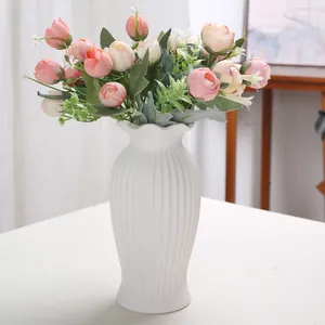 Elegant white fluted ceramic vase with artificial roses for Nordic home decor setup