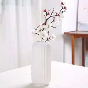 Nordic style white ribbed ceramic vase for flowers in a bright minimalist setting.