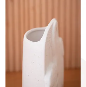 Makroansicht der weißen gesprenkelten Keramikvase in Elefantenform mit eleganter Textur