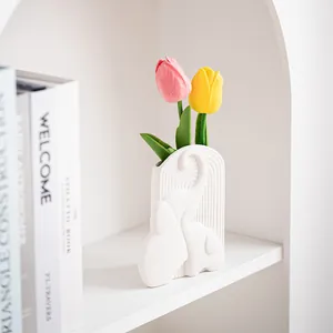 Minimalistische weiße Keramikelefantenvase mit dekorativen Tulpen auf dem Regal