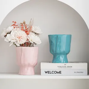Stylish Nordic crumpled ceramic vases in pink and teal for elegant home shelf decor