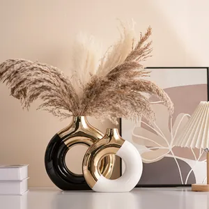Modern ceramic donut vases in black, white, and gold with dried pampas grass decor