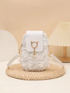 Primer plano de bolso bandolera blanco con flores, adorno de gato y borla de perlas.