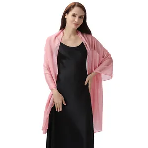Detalle de chal de seda rosa combinado con un vestido de satén negro para fiestas