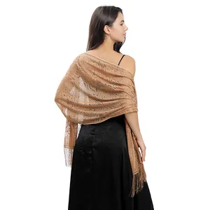 Detailed back view of a camel floral lace evening shawl with tassels over a black dress