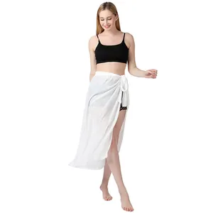 Ganzkörperansicht einer Frau in einem weißen Baumwoll-Sarong-Bikini-Überwurf