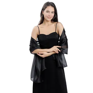 Elegante scialle da sera nero trasparente drappeggiato su un abito nero formale
