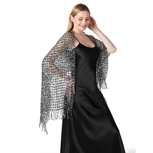 Detailed view of a sparkling sequined shawl worn over a black satin evening dress