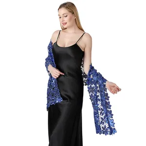 Dettaglio dello scialle in pizzo blu con paillettes su un elegante abito in raso.