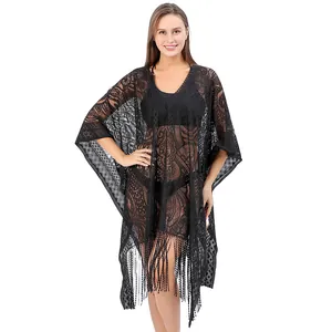 Detail view of a black paisley lace beach cover-up with elegant tassel fringe hem