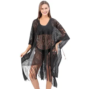 Detailed view of sheer black lace beach cover-up with paisley pattern and fringe tassels