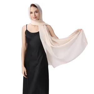 Châle élégant en mousseline beige clair drapé sur une robe de soirée noire pour un mariage