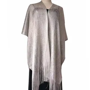 Dettaglio di scialle argento in filo metallico con eleganti frange per abiti da sera.
