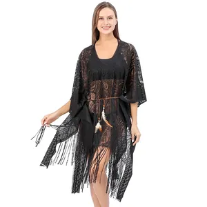 Detail view of black lace beach cover-up featuring intricate patterns and long tassel fringe