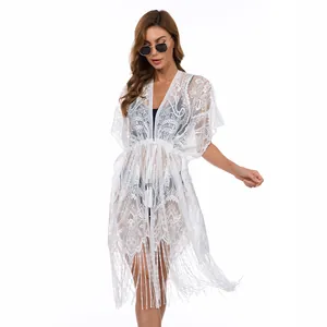 Cache-maillot élégant en dentelle blanche avec taille à cordon et détails de pompons
