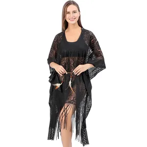 Dettaglio copricostume in pizzo nero con frange boho e cintura decorata con piume