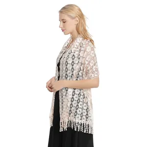 Close-up detail of an elegant pink floral lace shawl with long fringe tassels for evening gala