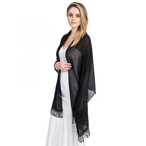 Elegant close-up of a black chiffon shawl with tassels worn by a model.