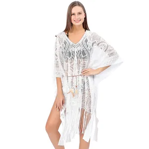Detail view of white lace beach cover-up with elegant V-neckline and stylish fringe hemline