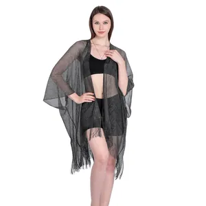 Full length view of a black sheer metallic shawl with tassels and sleeves for beachwear