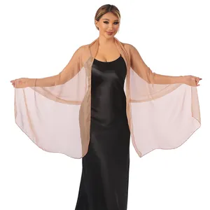 Close-up of elegant sheer champagne shawl wrap worn over a black satin evening dress